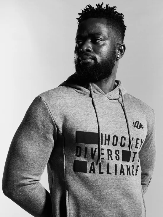 Diversity in Style: A man confidently models the Hockey Diversity Alliance sweater, expressing solidarity and support for inclusivity in hockey.